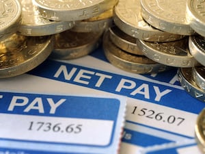 Coins on top of a net pay notice