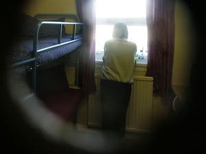 A female prisoner looks from the window of her cell