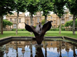 Bronze sculpture La Promesse in a garden