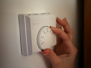 Someone adjusts their heating on a dial