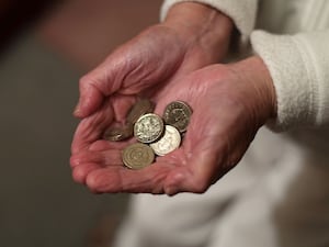 The hands of a pensioner holding coins