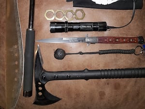 Various weapons, gloves and a mask lying on a table