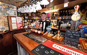 Layton Williams helps to pour the pints behind the bar