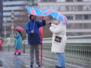 People walking in the wind and rain on Westminster Bridge, in London on Sunday