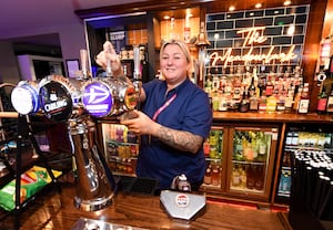 Staff member Amanda Warriner works on pouring a pint of Carling