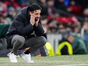 Manchester United manager Ruben Amorim crouches on the touchline with his head in his hands