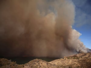 Plumes of smoke caused by the Hughes Fire rise over Lake Castaic in California