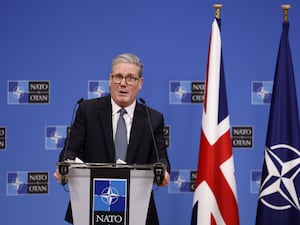 Sir Keir Starmer speaking next to some flags in Brussels