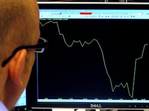 A man views a graph on a computer screen