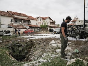 An Israeli police bomb squad inspects the site after a missile fired from Lebanon hit the area in Petah Tikva, on the outskirts of Tel Aviv, Israel