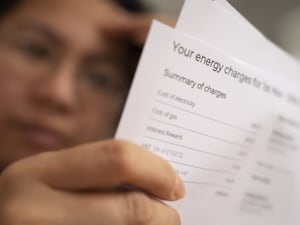 A person holding an energy bill and looking concerned