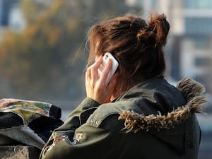 The back of a woman using a mobile hone