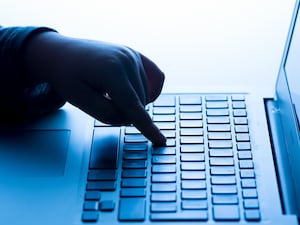 A child presses a key on a laptop