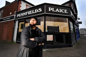 Prince Hussain, owner of Pennfields Plaice, Wolverhampton, next to his boarded up windows after the chippy was targeted on New Year's Eve