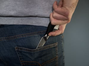 A model poses holding a knife