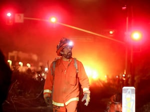 A California Department of Corrections hand crew works containment lines ahead of the Palisades Fire