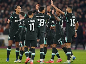 Liverpool's players celebrate after Mohamed Salah scored their third goal at the London Stadium