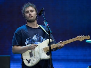 Sam Fender on stage with a guitar