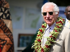 King Charles in sunglasses and floral garland