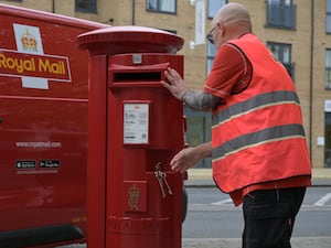 Royal Mail postman at a post box