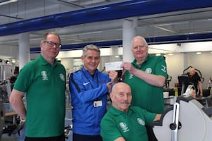 Robin Shields, left, and John Corser, right, present the cheque to Russell Tipson as Terry Astley demonstrates how the exercise machines are helping his rehabilitation.

 