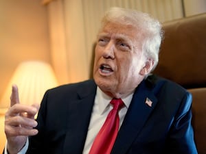 President Donald Trump speaks to reporters aboard Air Force One