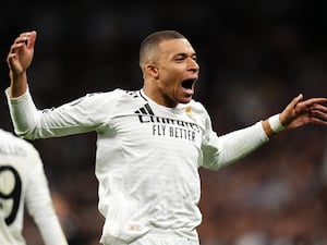 Kylian Mbappe holds his arms out to celebrate