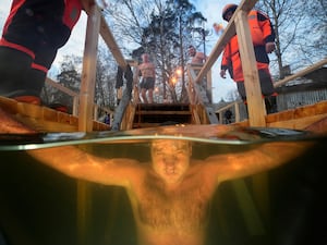 Man under water, with other bathes waiting behind him