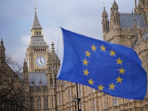 A European Union flag flies in front of the Houses of Parliament