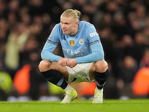 Erling Haaland crouches down in frustration after Manchester City's loss to Manchester United