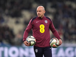 Lee Carsley carrying two footballs