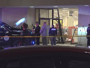 Police outside shop building with damaged doors