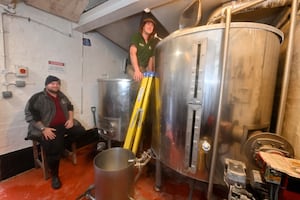 Brewer Christian Horton and assistant brewer Anthony Stokes watch over one of the mash tuns