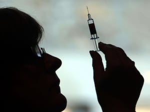 A nurse preparing to give a patient a vaccine