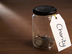 Coins in a jam jar marked charity