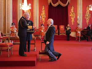 Sir John Rutter kneels before the King as he is knighteddon