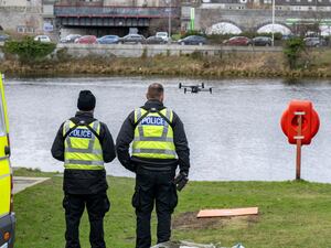 The backs of police officers looking towards a river