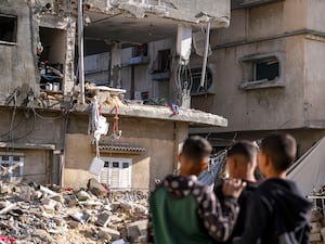 Palestinians look at a damaged building following an overnight Israeli strike in Deir al-Balah (Abdel Kareem Hana/AP)