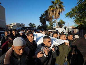 Palestinians carry the body of victim of an overnight Israeli strike, during a funeral