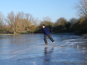 A man skates on a frozen flooded field