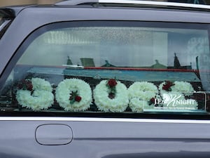 Flowers in the hearse carrying the coffin of Harvey Willgoose spell out the word 'Goose'