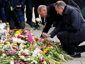 German Chancellor Olaf Scholz places flowers at the site of the attack