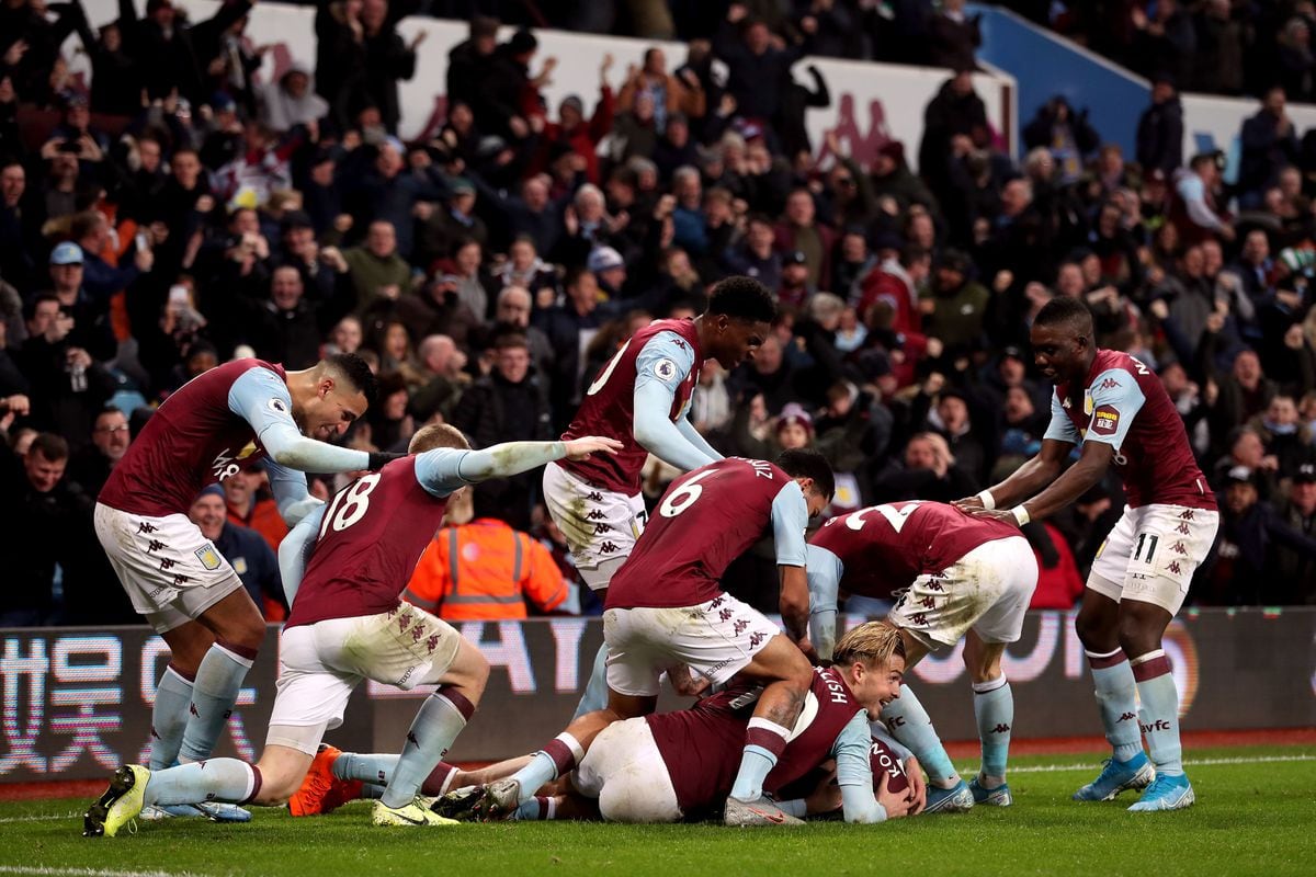  Aston Villa players celebrating a goal in front of a crowd of fans at Villa Park.