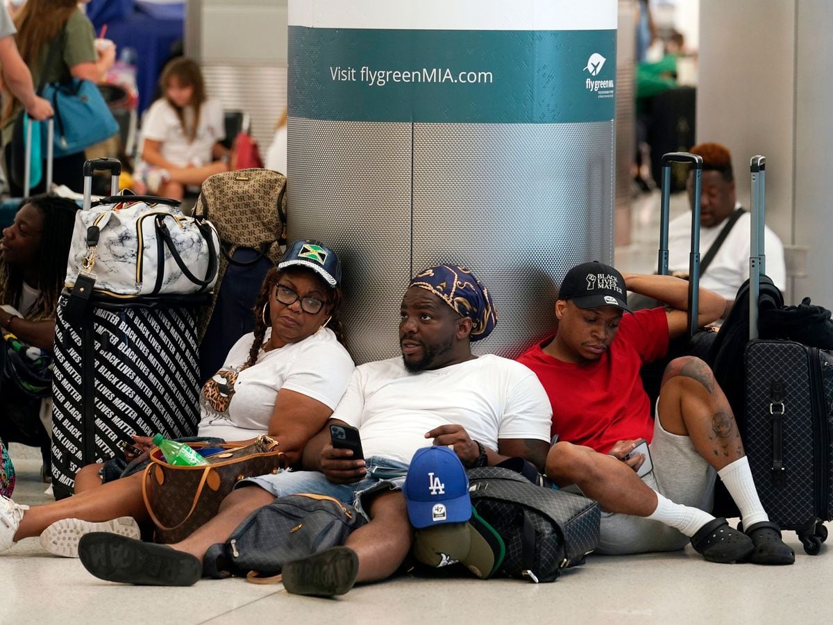 Alisson Bryan, Marcel Bryan and Terry Craig wait at Miami International Airport to check in their luggage for their flight to Missouri